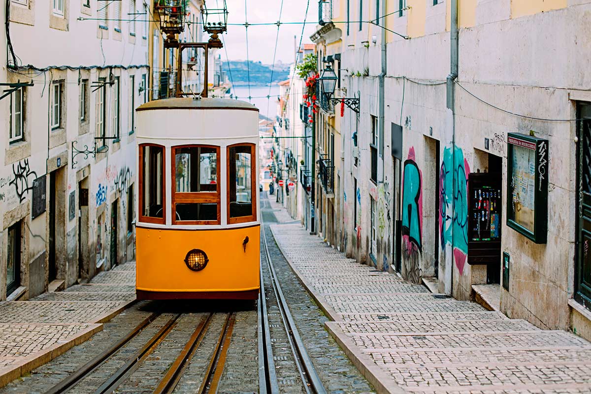 Electric tram heading up an old street in Lisbon historic center.