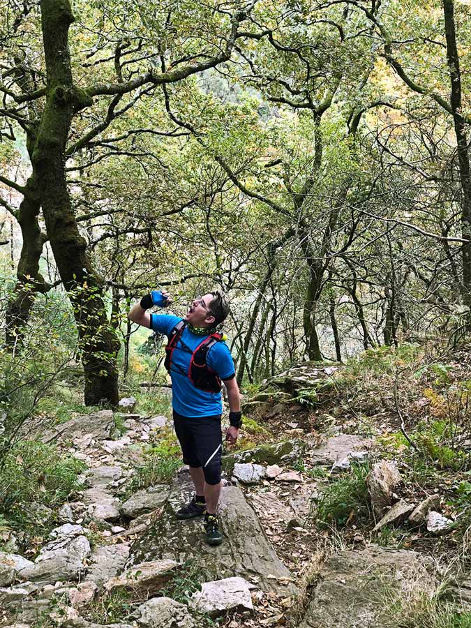 Pedro drinking water from a soft flask bottle during a trail in Arouca.