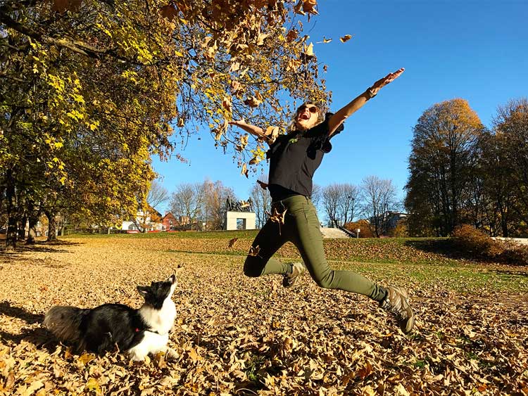 Sara and Rafa jumping over a field of leaves, at Byparken in Copenhagen
