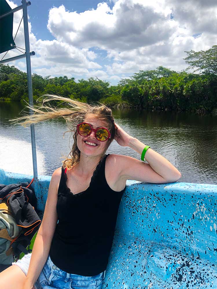 Sara a bordo de um barco no rio, no Belize.