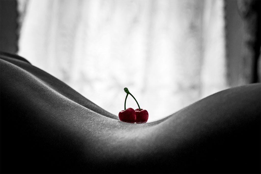 Imagem sensual das costas de uma mulher com duas cerejas em cima
