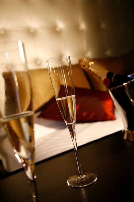 Pormenor de flutes e garrafa de champanhe na suite Paris do Motel Flamingo
