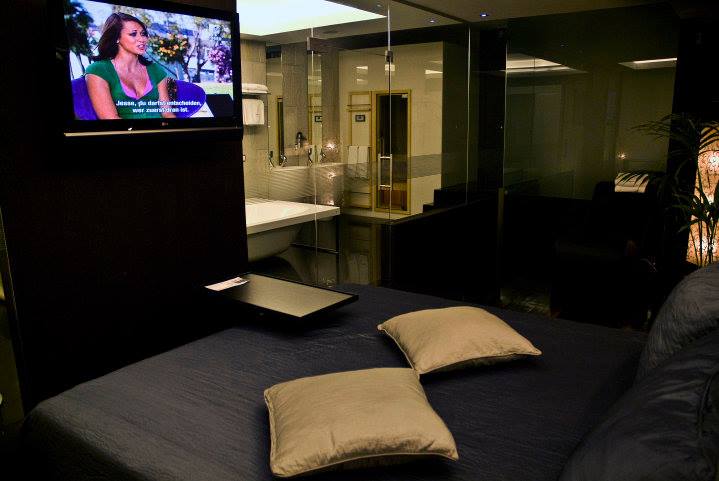 Zona de dormir com cama e televisão, na suite Flamingo