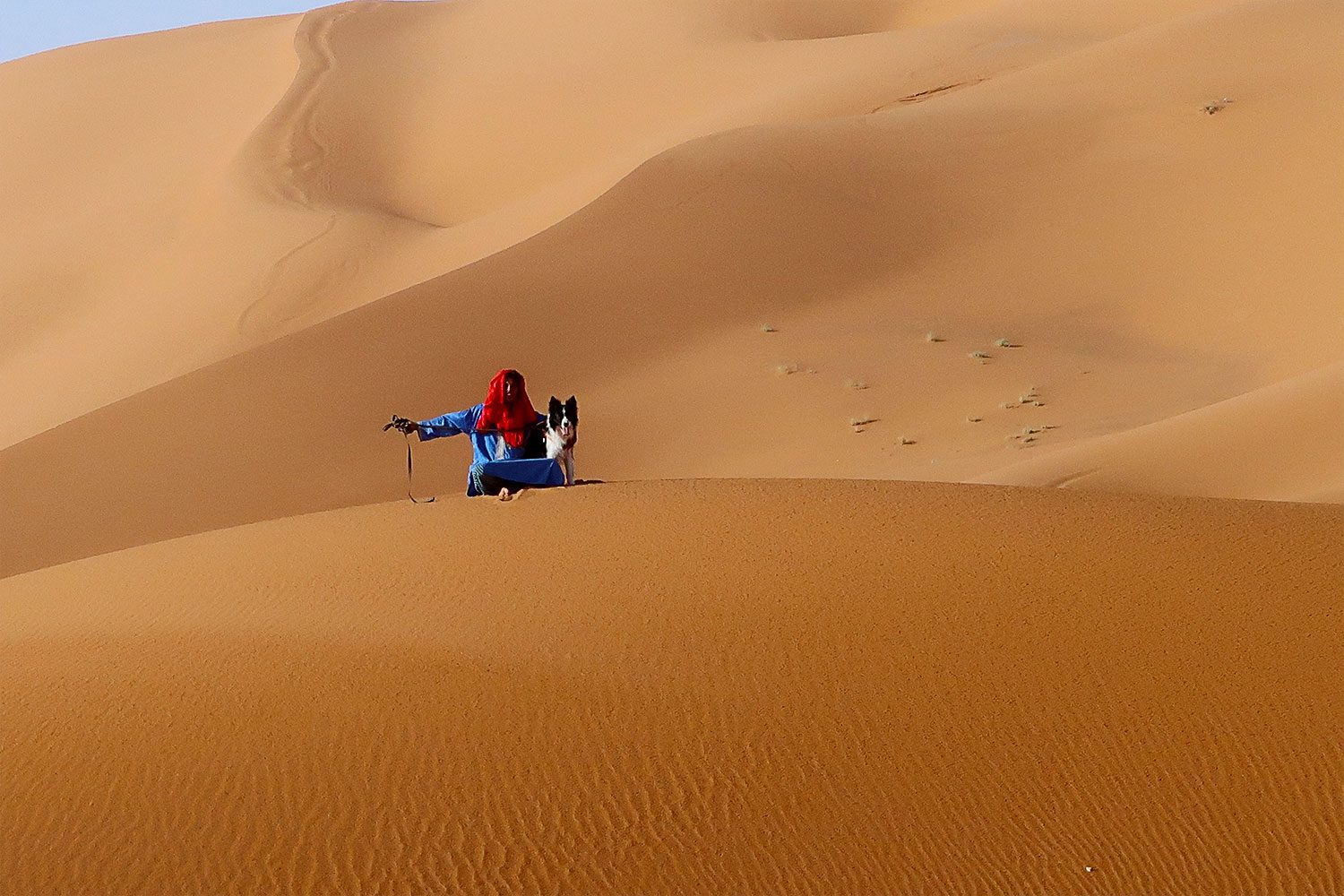Rafa on a leash with a Moroccan gentleman in the Sahara desert.
