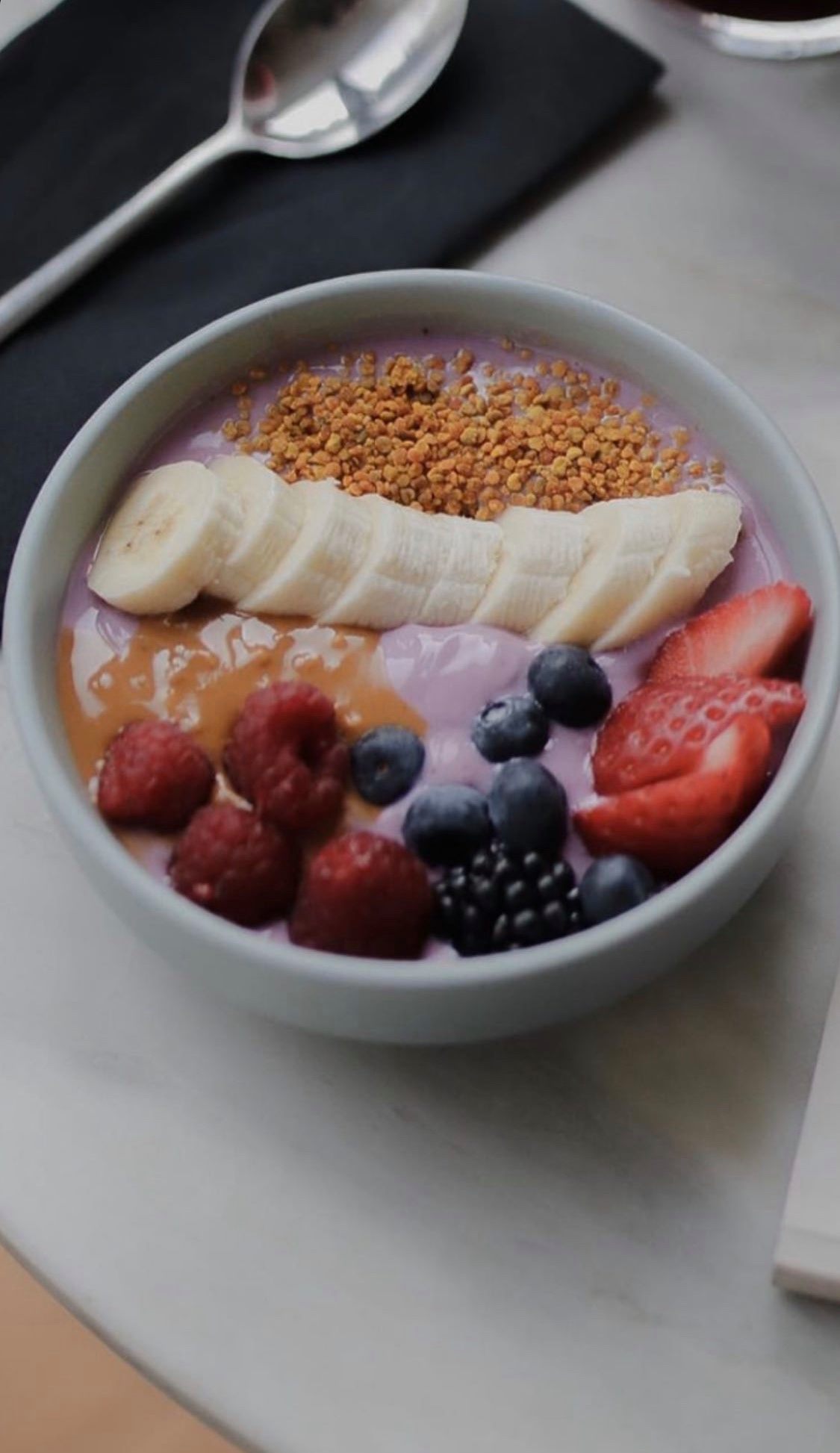 Tigela com iogurte, banana, compota, frutos vermelhos e sementes no Dear Breakfast.