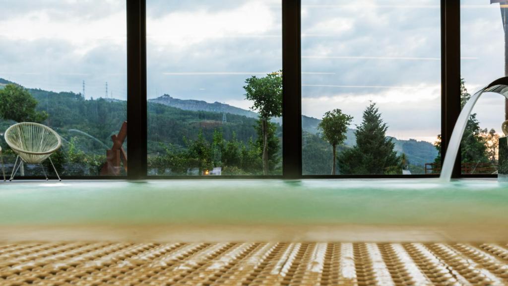 Piscina com jato de água e vistas panorâmicas, no Agrinho Suites & SPA Gerês, no Parque Nacional Peneda Gerês