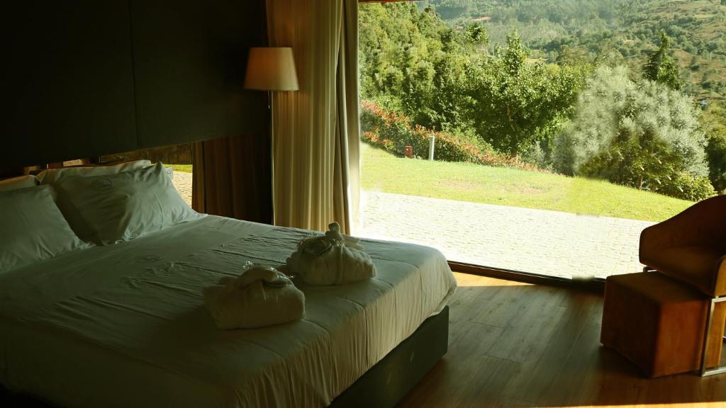 Quarto com cama de casal e vista para o jardim, no Agrinho Suites & SPA Gerês, no Parque Nacional Peneda Gerês