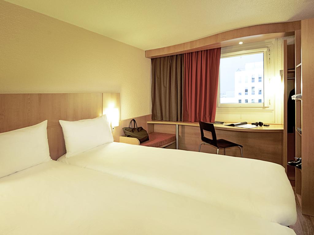Quarto de hotel do Ibis Lisboa Sintra com duas camas e secretária.