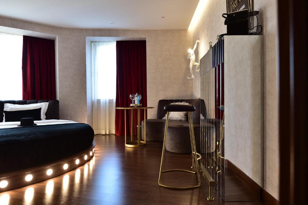 Quarto temático com cama redonda com luzes e bancos altos no Maxime Hotel Lisbon.