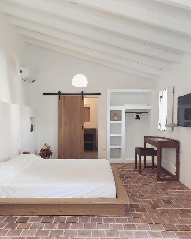 Quarto minimalista com cama de casal, chão de tijoleira e wc privativo no FARMHOUSE OF THE PALMS