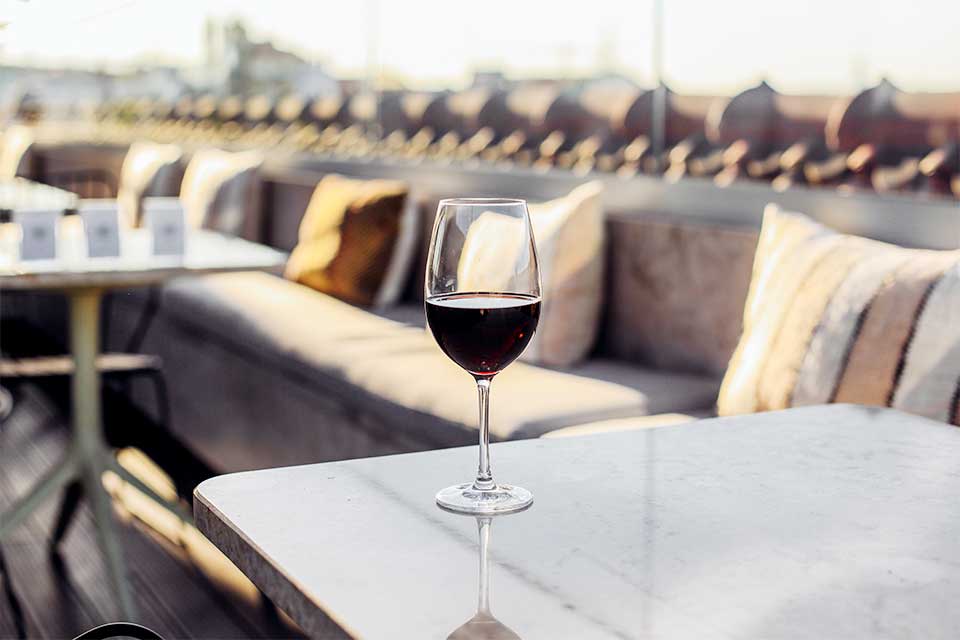 Copo de vinho em cima de uma mesa, num rooftop em Lisboa