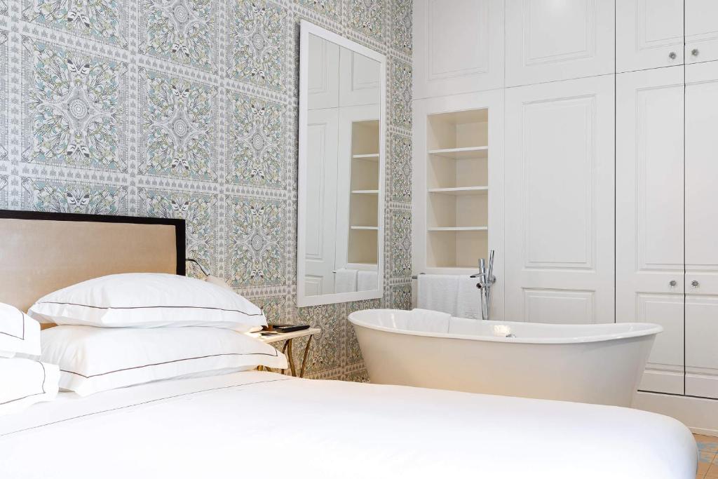 Quarto com banheira decorado em tons de branco no Santiago de Alfama Boutique Hotel.