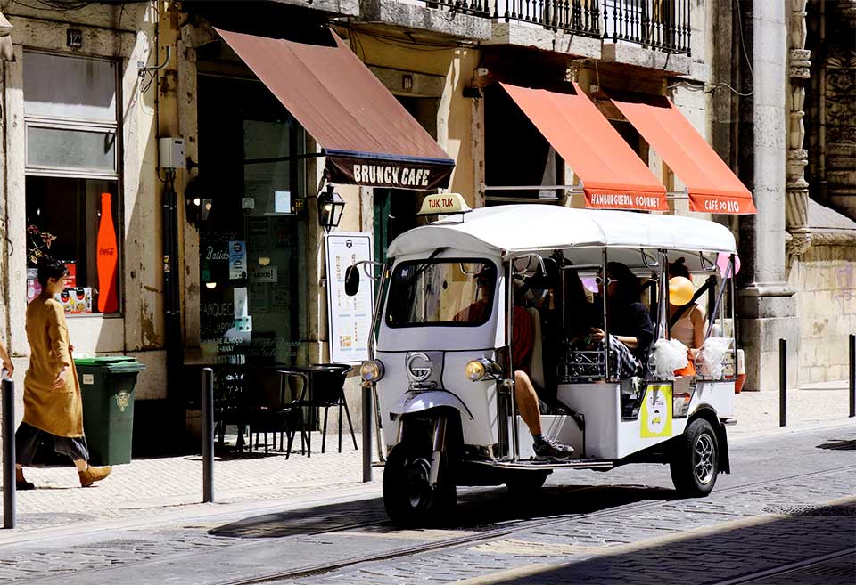 Tuktuk com turistas, no centro histórico de Lisboa