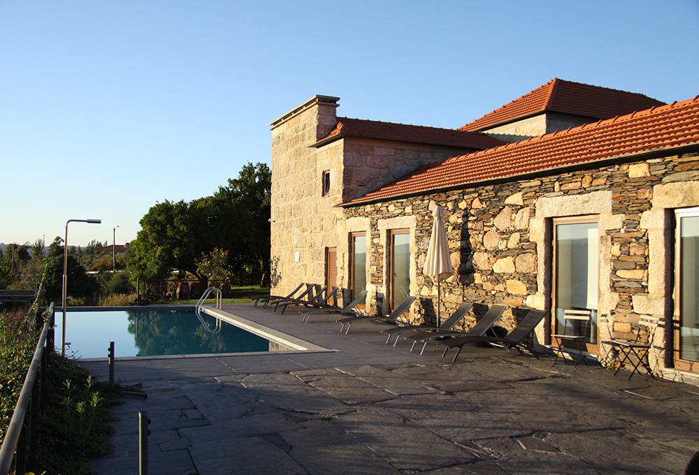 Exterior da Casa Valxisto, em Penafiel, com piscina e espreguiçadeiras no terraço