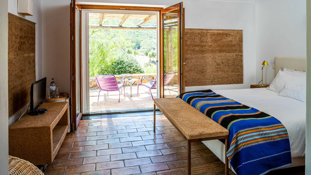 Quarto com cama de casal e mobiliário e acabamentos em cortiça, no Monte da Vilarinha, na Costa Vicentina