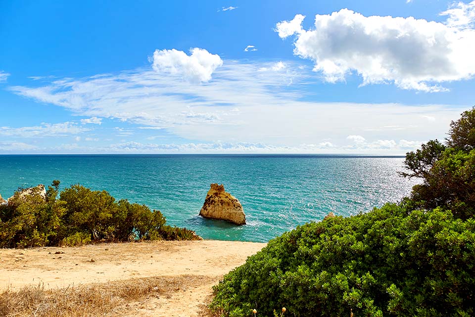 Vista para o mar do Algarve, com uma rocha isolada no centro